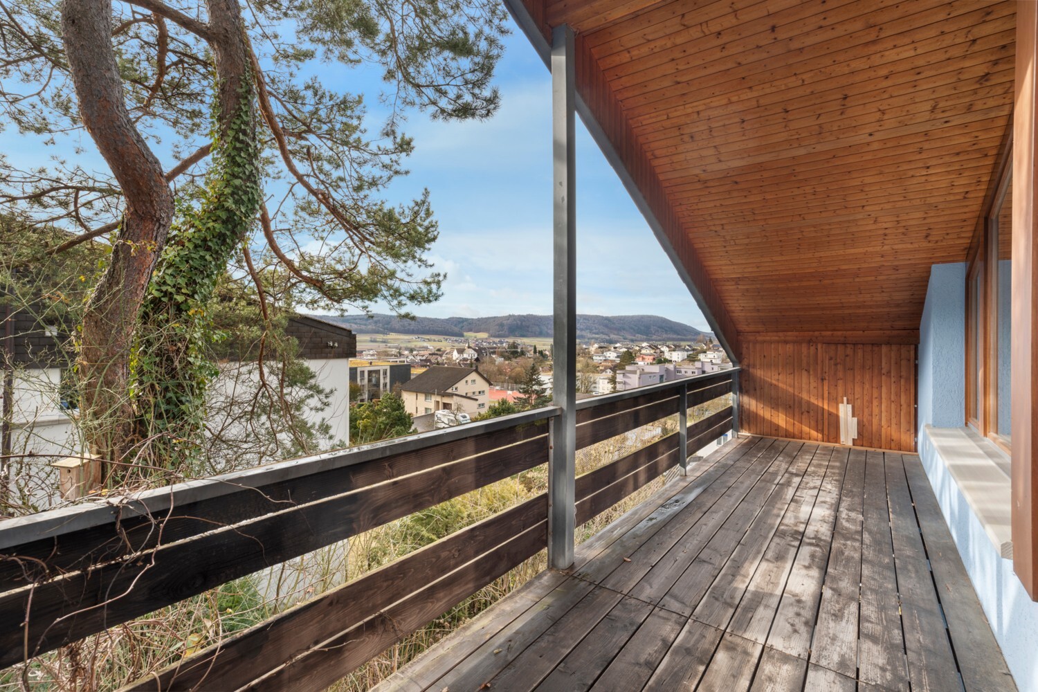 Überdachter Balkon mit Holzboden und Weitblick