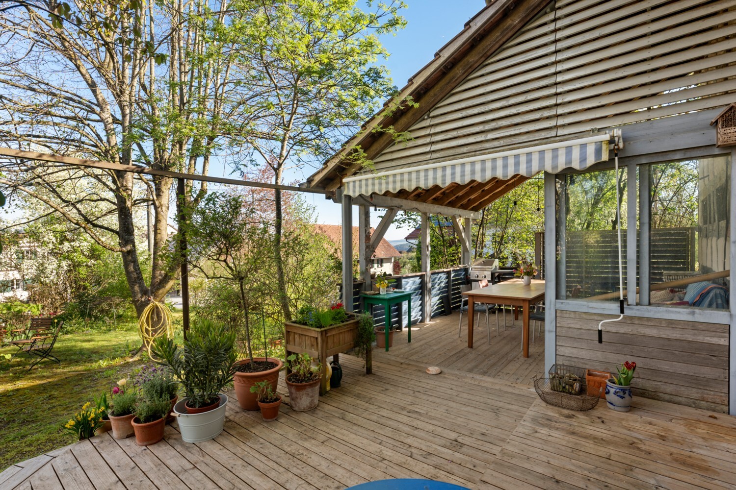 Holzterrasse mit Garten und überdachtem Sitzbereich