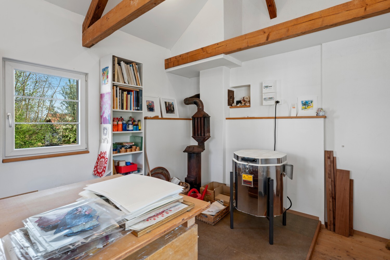 Atelierraum mit Holzofen und sichtbaren Deckenbalken