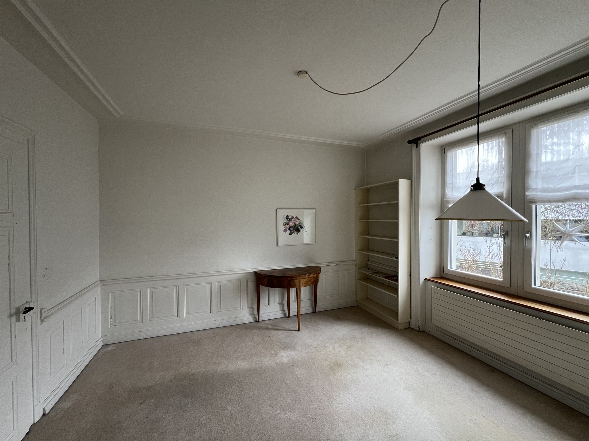 Leeres, helles Zimmer mit Stuck und Fensterbank