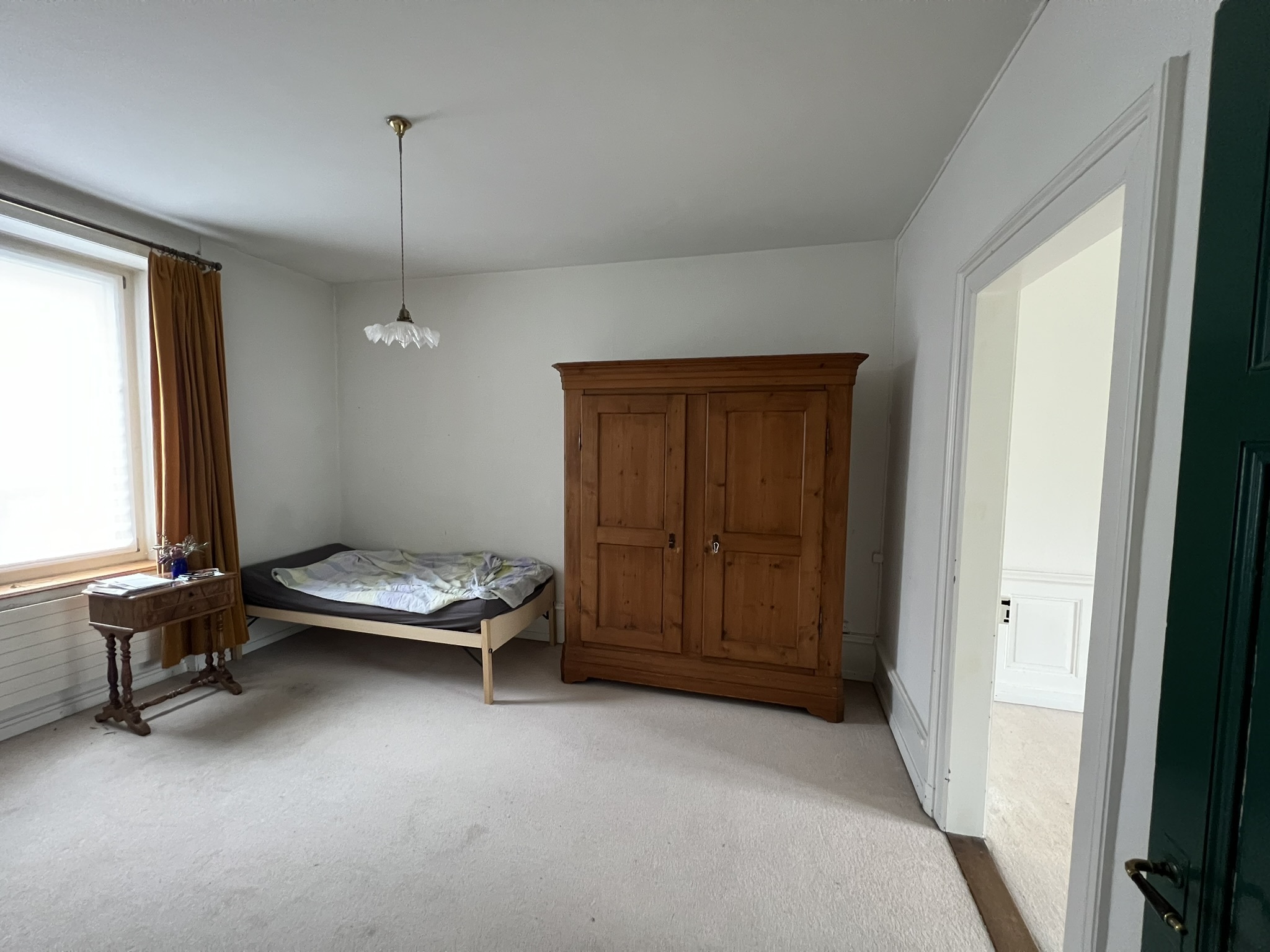 Schlichtes Schlafzimmer mit Einzelbett und Kleiderschrank