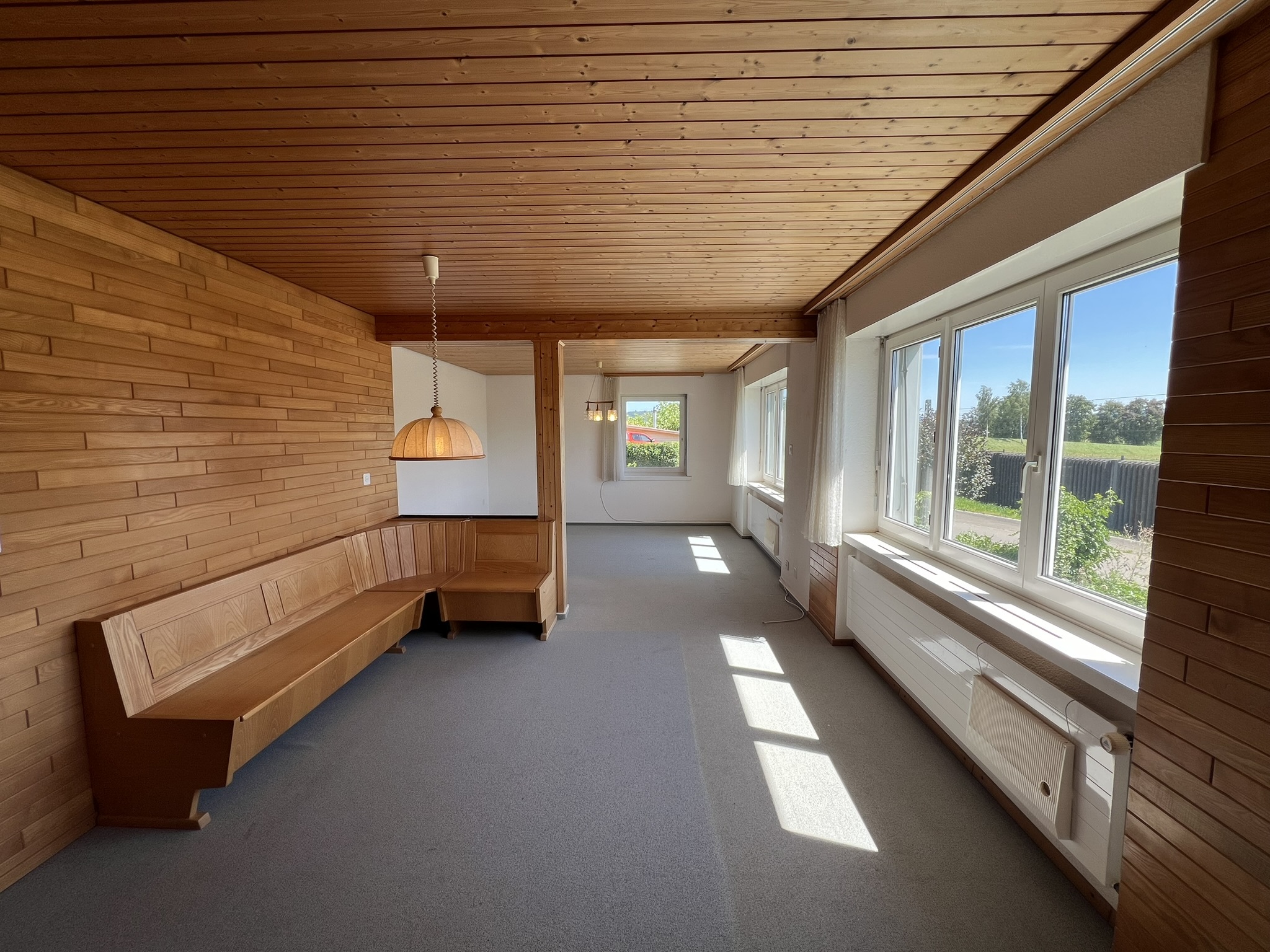 Holzvertächter Wohnraum mit Fensterfront
