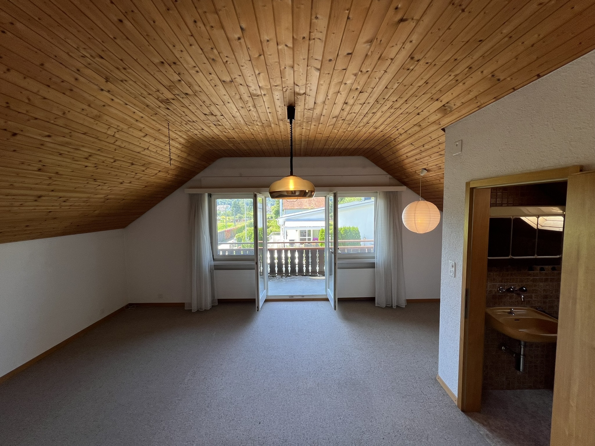 Dachgeschossraum mit Balkon und kleinem WC-Bereich