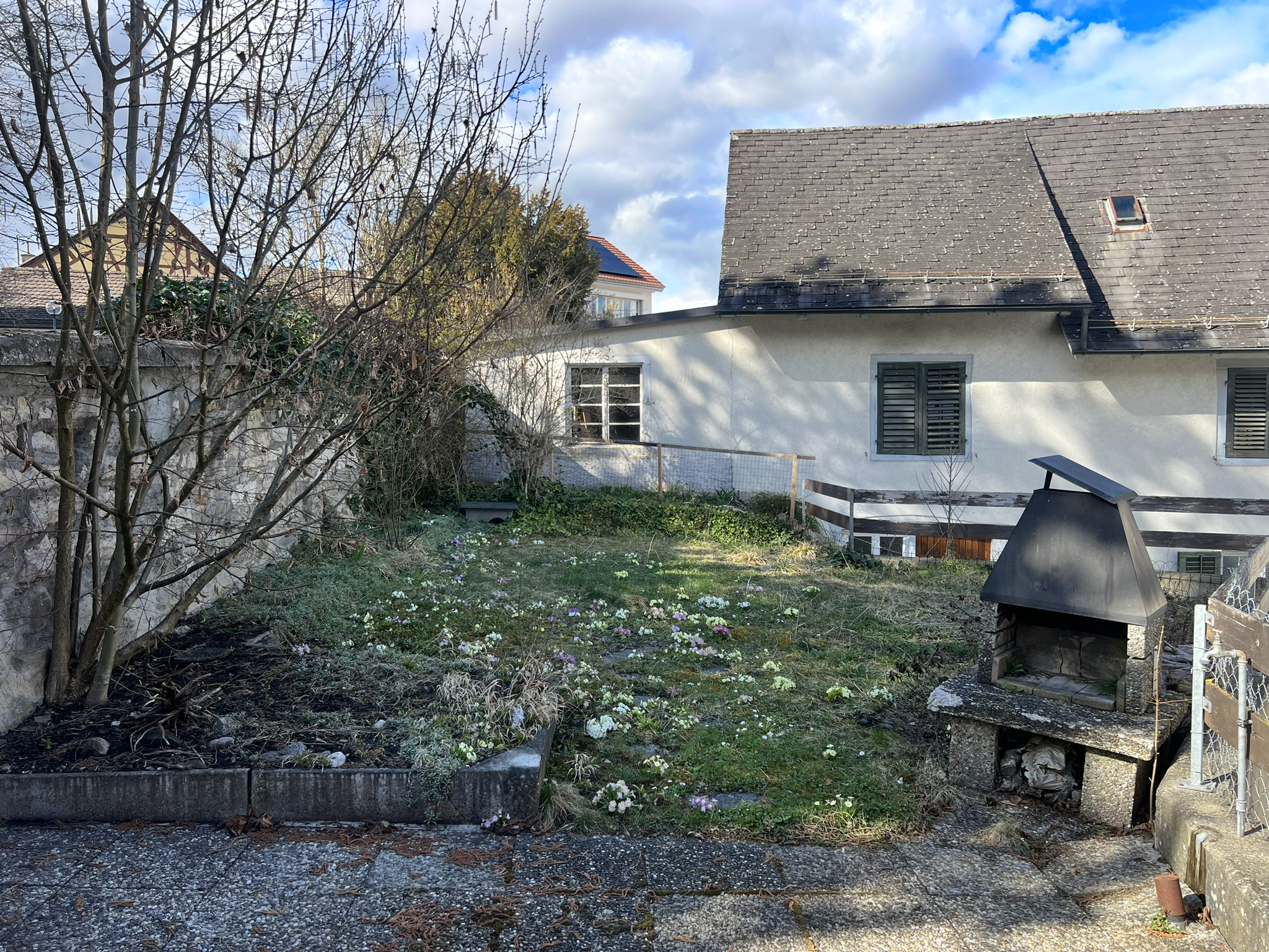 Verwachsener Garten mit Anbau und Schornstein