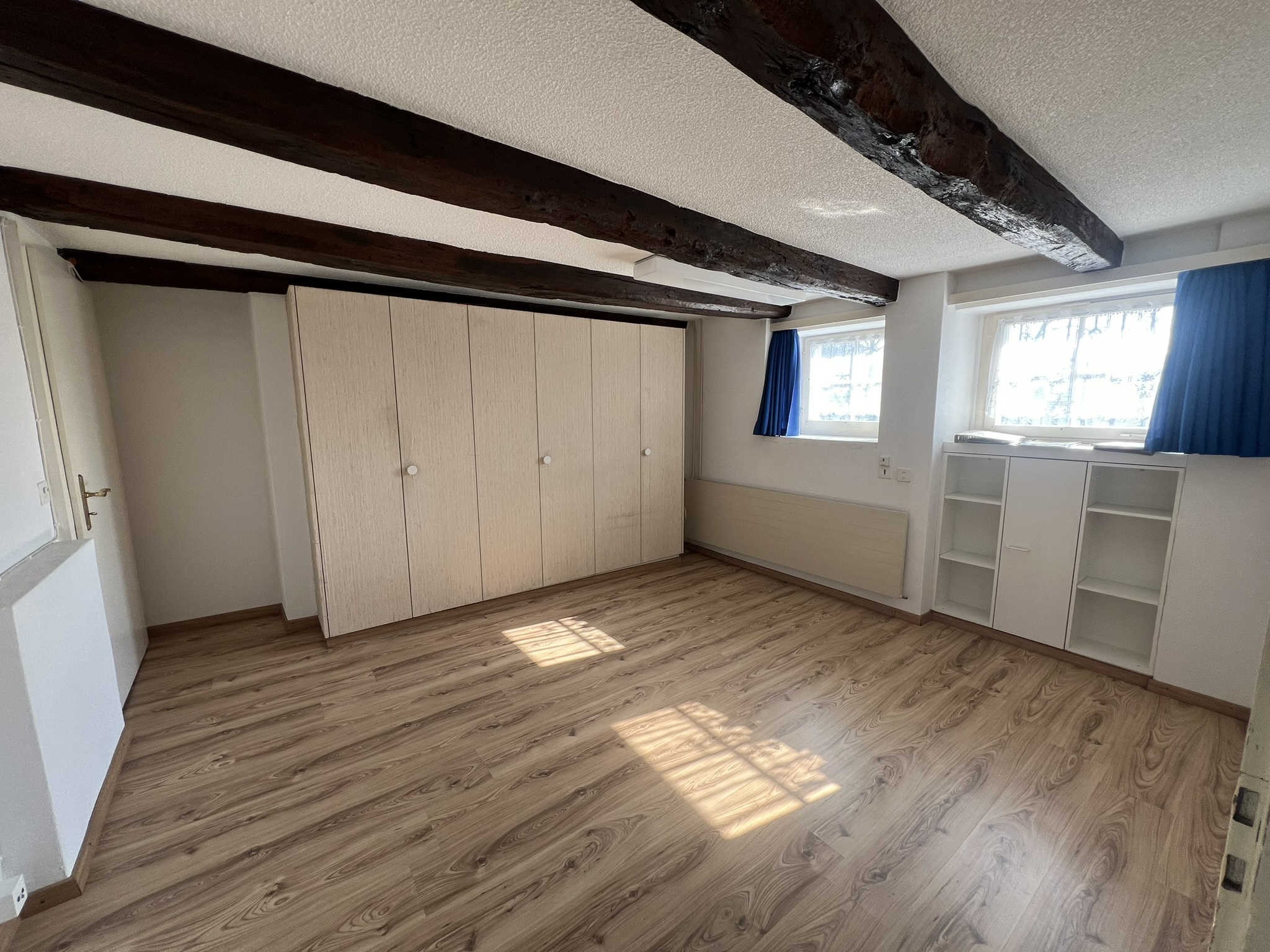 Helles Schlafzimmer mit sichtbaren Holzbalken
