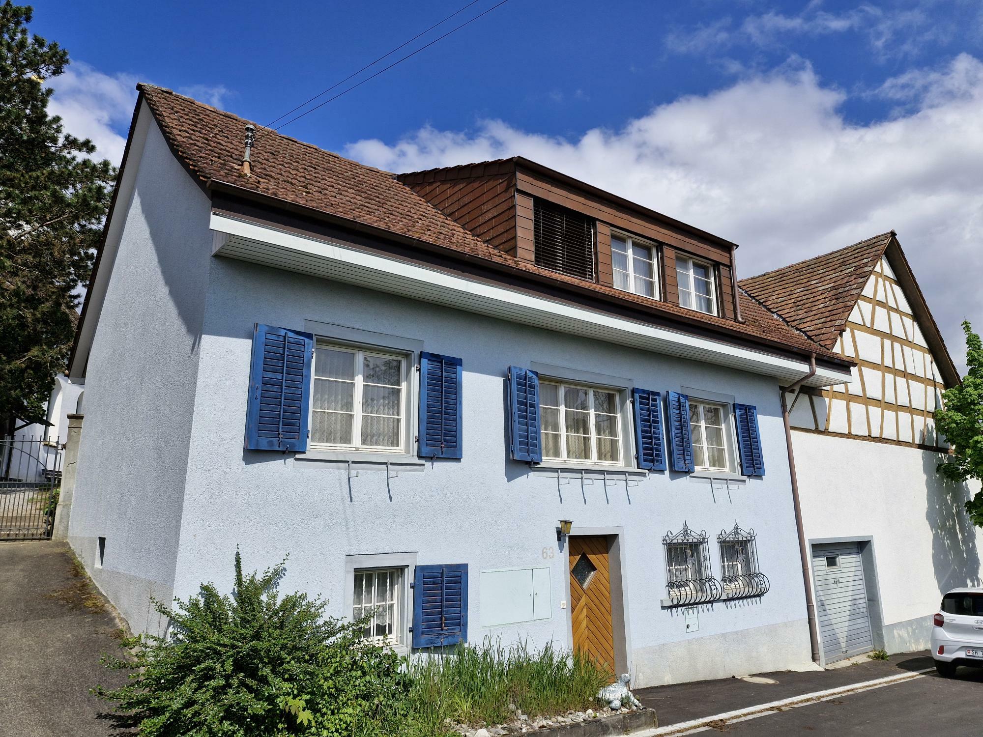 Historisches Wohnhaus mit Satteldach und blauen Fensterläden