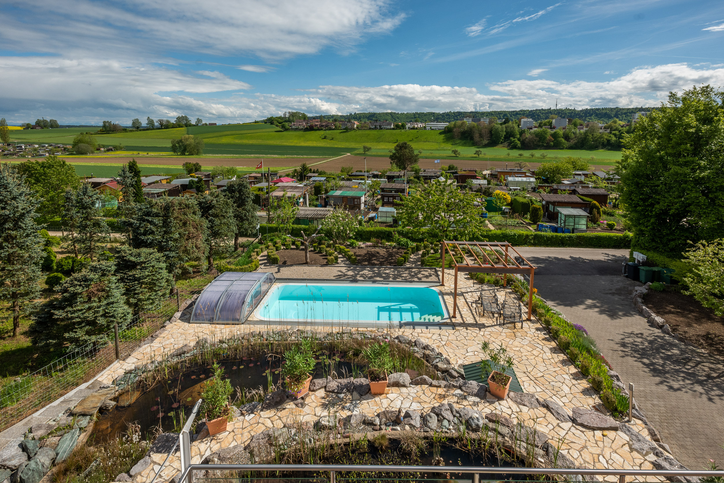 Außenansicht eines Gartens mit Pool und Panorama