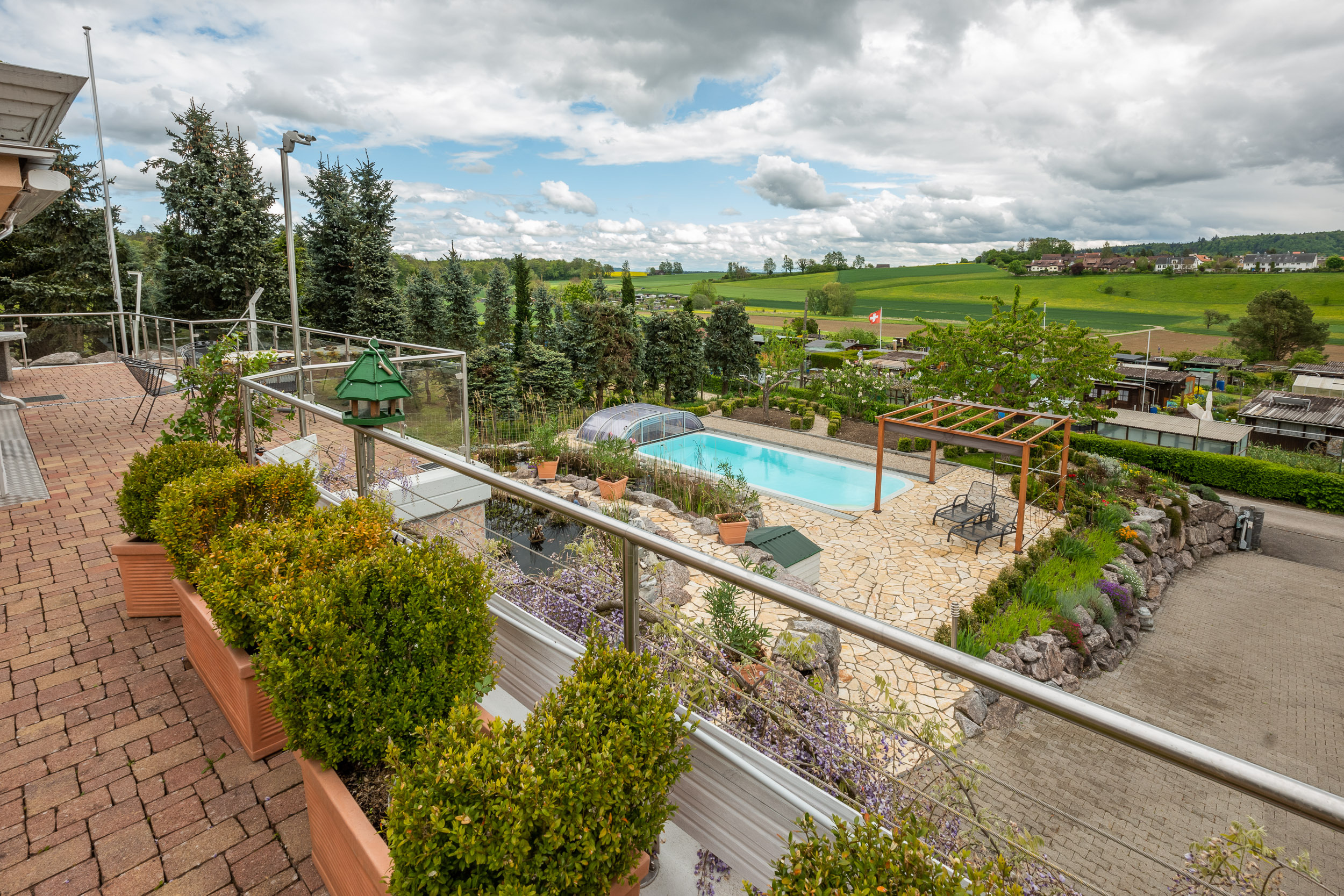 Terrasse mit Poolblick über grüne Landschaft