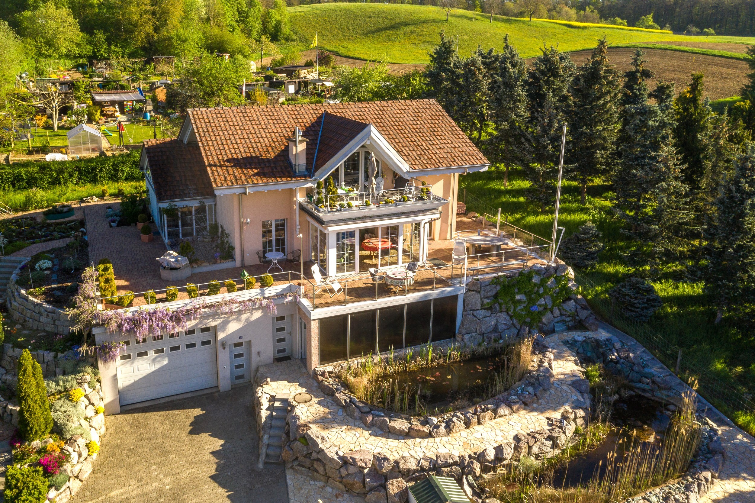 Luftaufnahme eines Einfamilienhauses mit Terrasse und Naturgarten