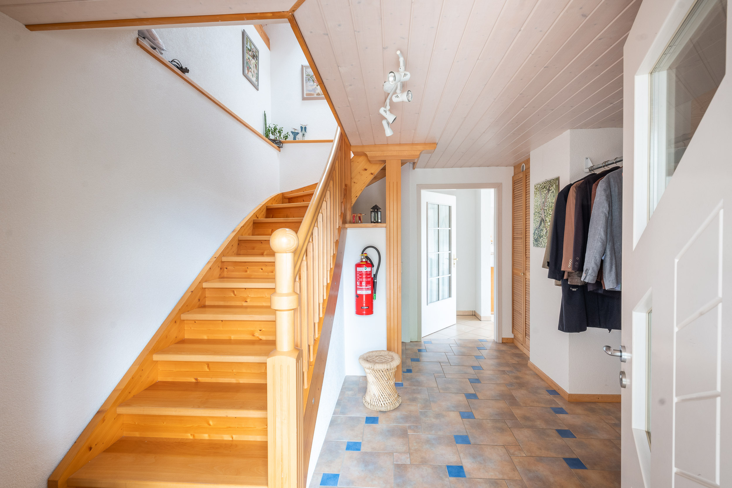Heller Flur mit Holztreppe