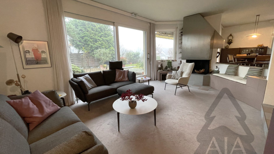 Helles Wohnzimmer mit Kamin und Gartenblick