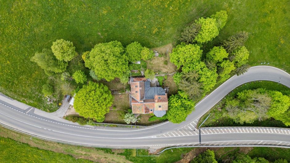 Luftaufnahme eines Wohnhauses an einer kurvigen Straße