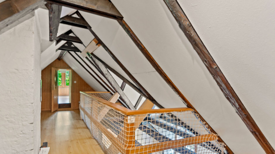 Dachgeschossflur mit sichtbaren Holzbalken