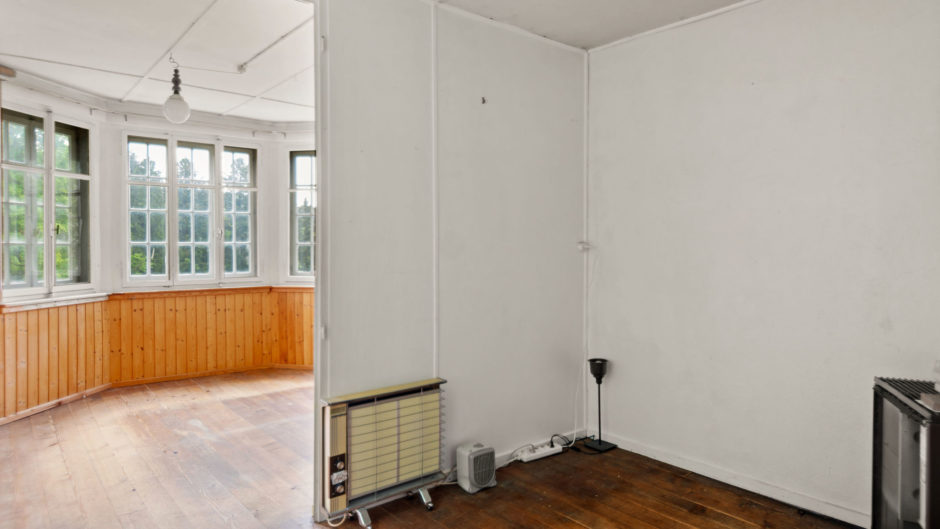 Leerer Raum mit großen Fenstern und Holzverkleidung
