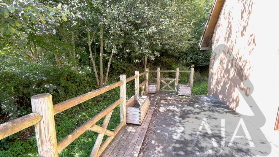 Außenbereich mit Holzterrasse und Zaun