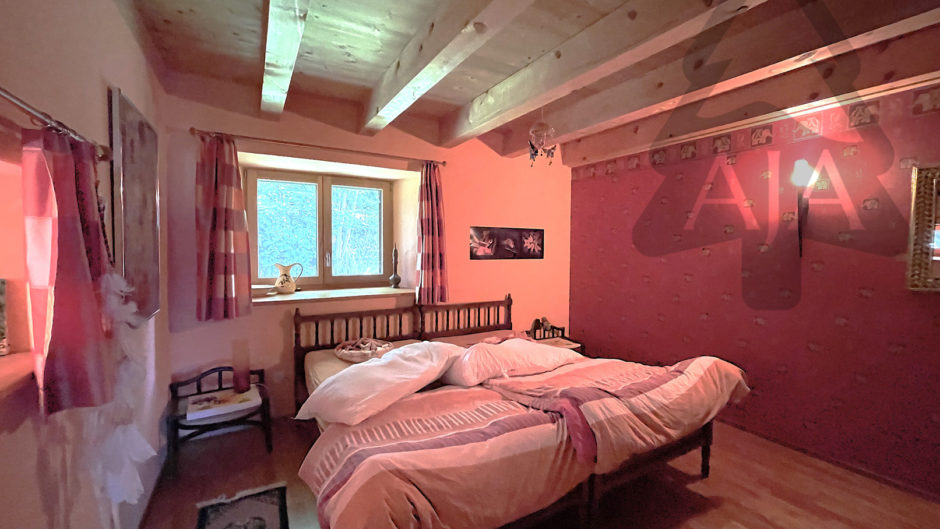Gemütliches Schlafzimmer mit sichtbaren Holzbalken