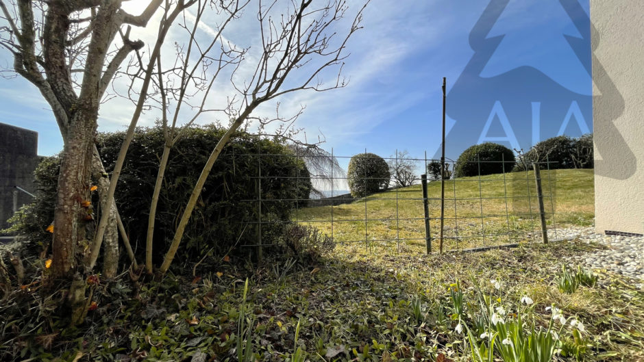 Garten mit Zaun und Rasenhang