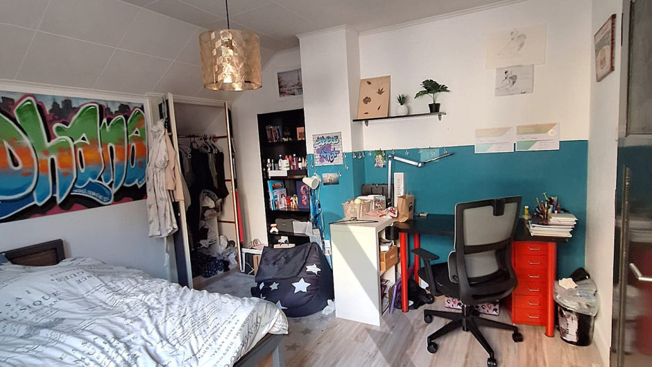 Jugendzimmer mit Schreibtisch und Bett