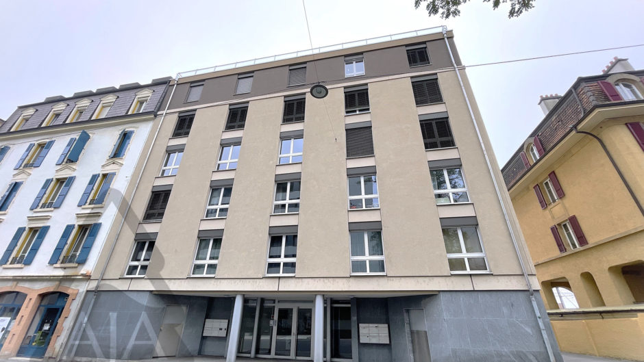 Mehrfamilienhausfassade in enger Straßenszene
