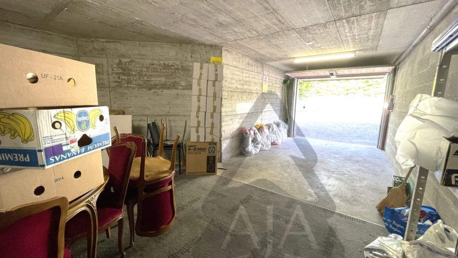 Betonggarage mit gelagerten Möbeln und Kartons