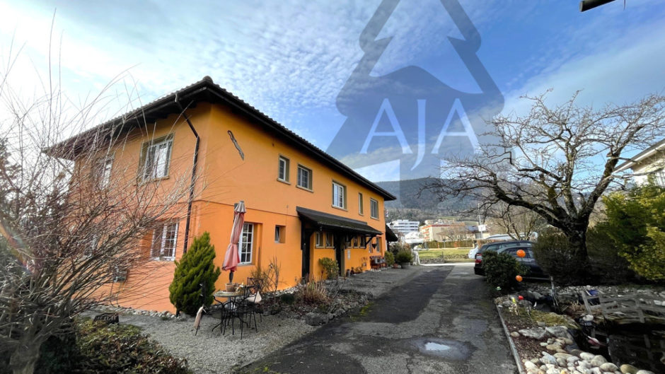 Außenansicht eines orangefarbenen Wohnhauses mit Zufahrt