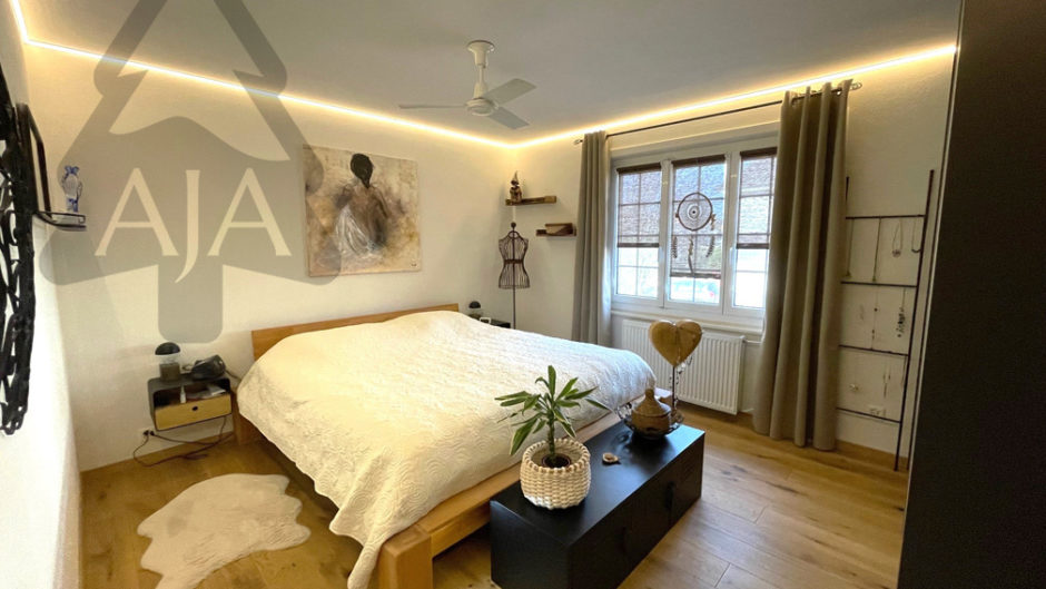 Gemütliches Schlafzimmer mit Holzbett und indirekter Beleuchtung