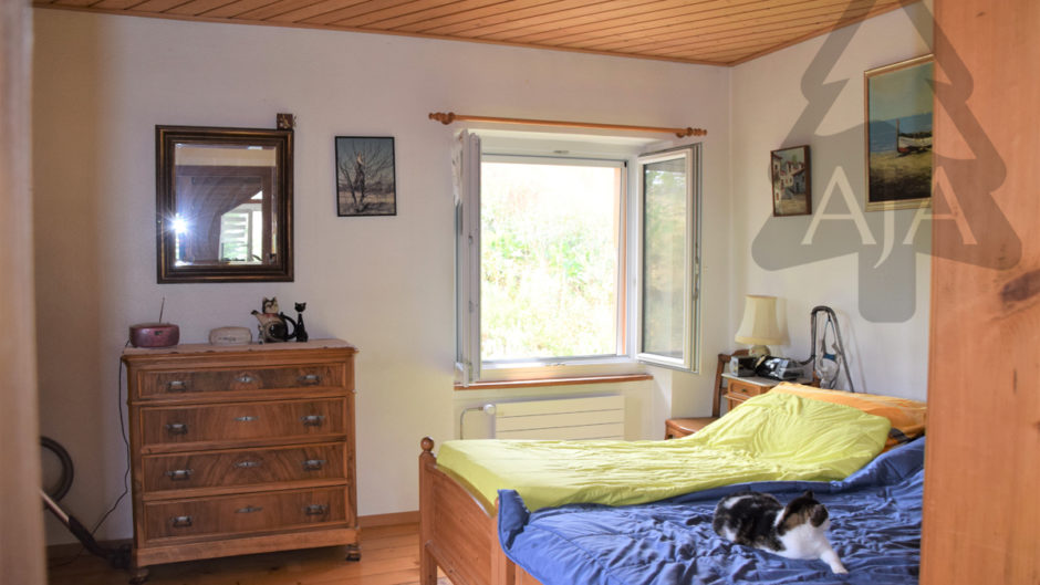 Schlafzimmer mit Holzmöbeln und offenem Fenster