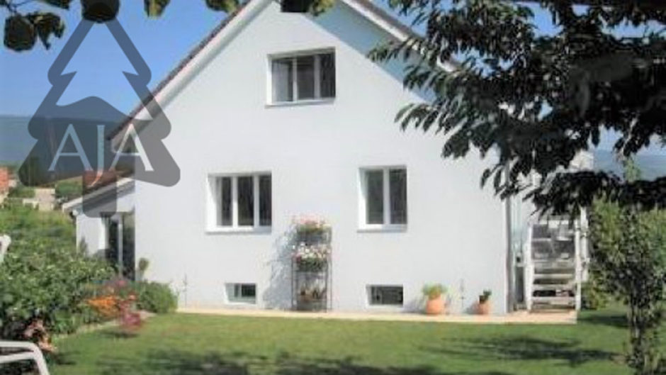 Außenansicht eines weißen Wohnhauses mit Garten