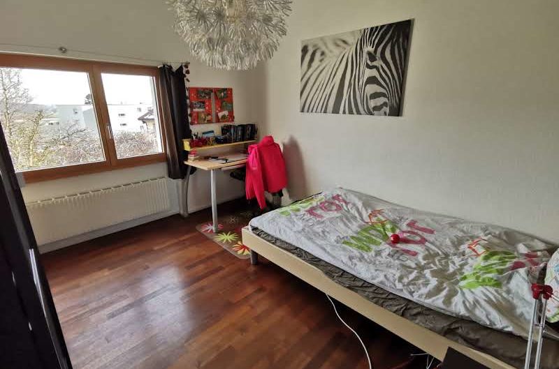 Kinder-/Jugendzimmer mit Holzfenster und Bett