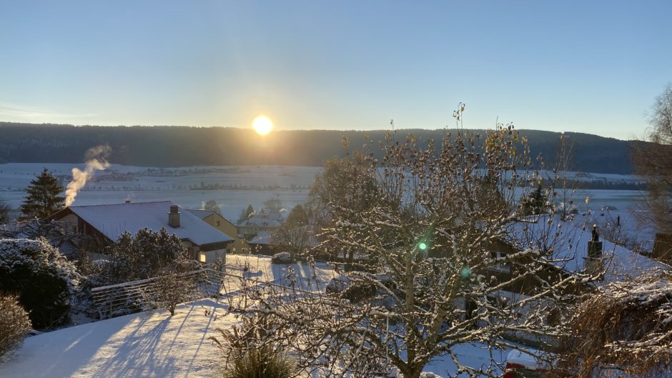 Winterliche Landschaft mit Sonnenaufgang über einem Tal