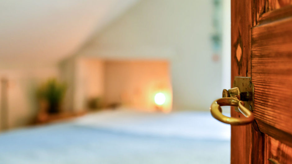 Schlafzimmer mit geöffneter Holztür