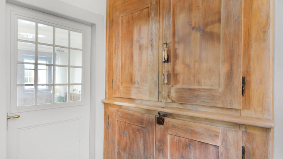 Flur mit großem Holzschrank und weißer Tür