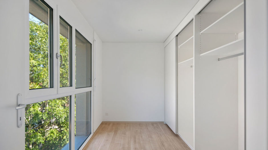 Heller begehbarer Kleiderschrank mit großen Fenstern