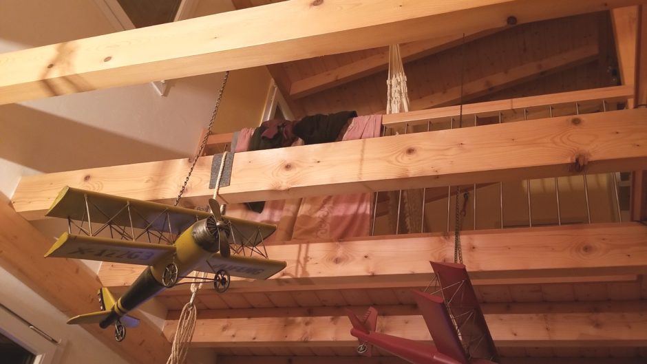 Holzgalerie mit hängenden Modellflugzeugen