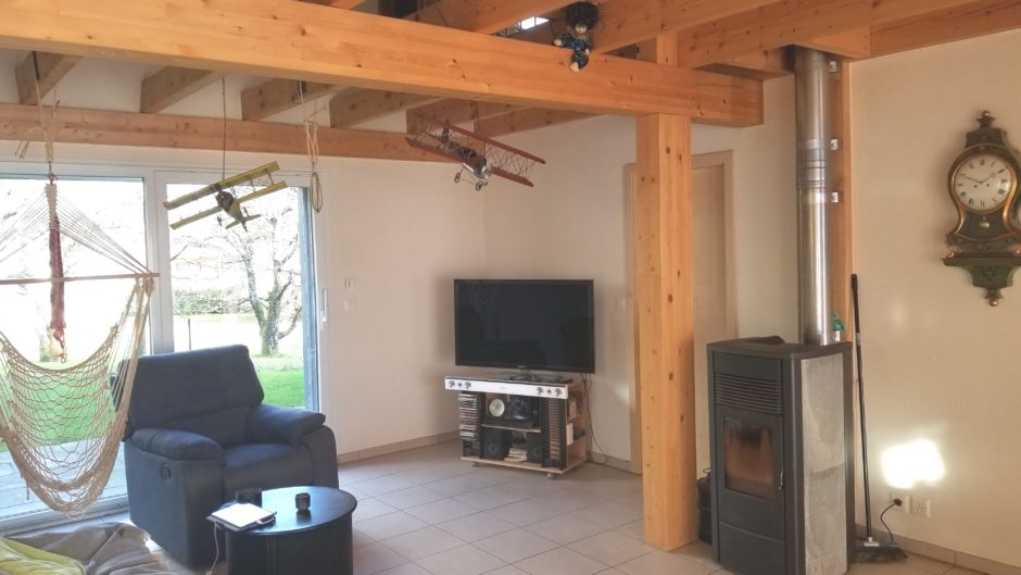 Wohnzimmer mit Kamin und sichtbaren Holzbalken