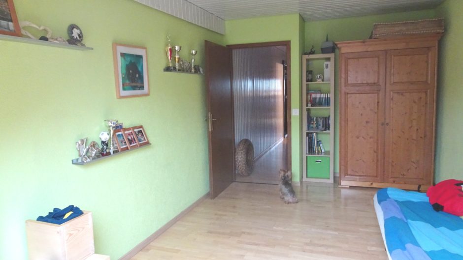 Kinderzimmer mit grünen Wänden und Holzschrank