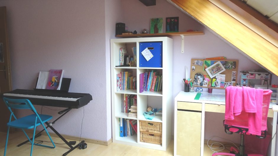 Helles Dachzimmer mit Schreibtisch und Keyboard