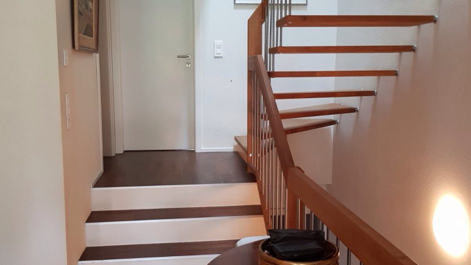 Heller Treppenflur mit Holztreppe