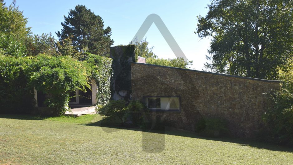 Gartenansicht eines Hauses mit Natursteinfassade