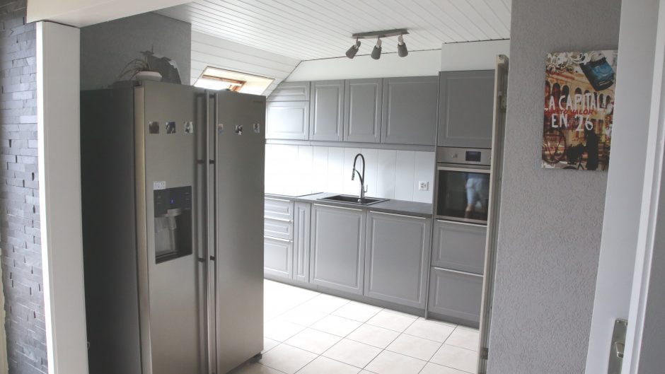 Moderne graue Küche mit Edelstahl-Kühlschrank