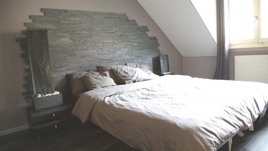Schlafzimmer mit Dachschräge und Steinwand