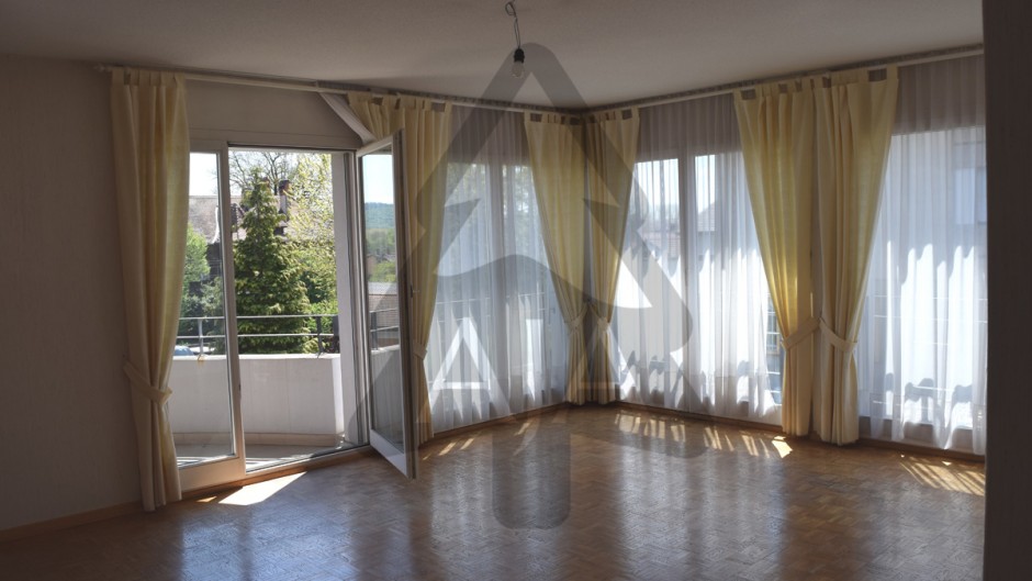 Heller Wohnraum mit Balkon und großen Fenstern