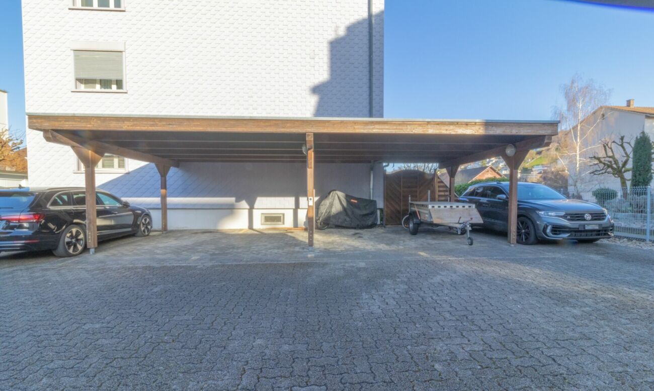 Überdachter Stellplatz vor einem Wohnhaus