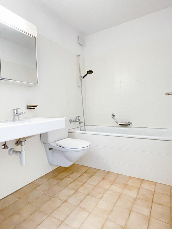 Kleines weißes Badezimmer mit Wanne und Wand-WC
