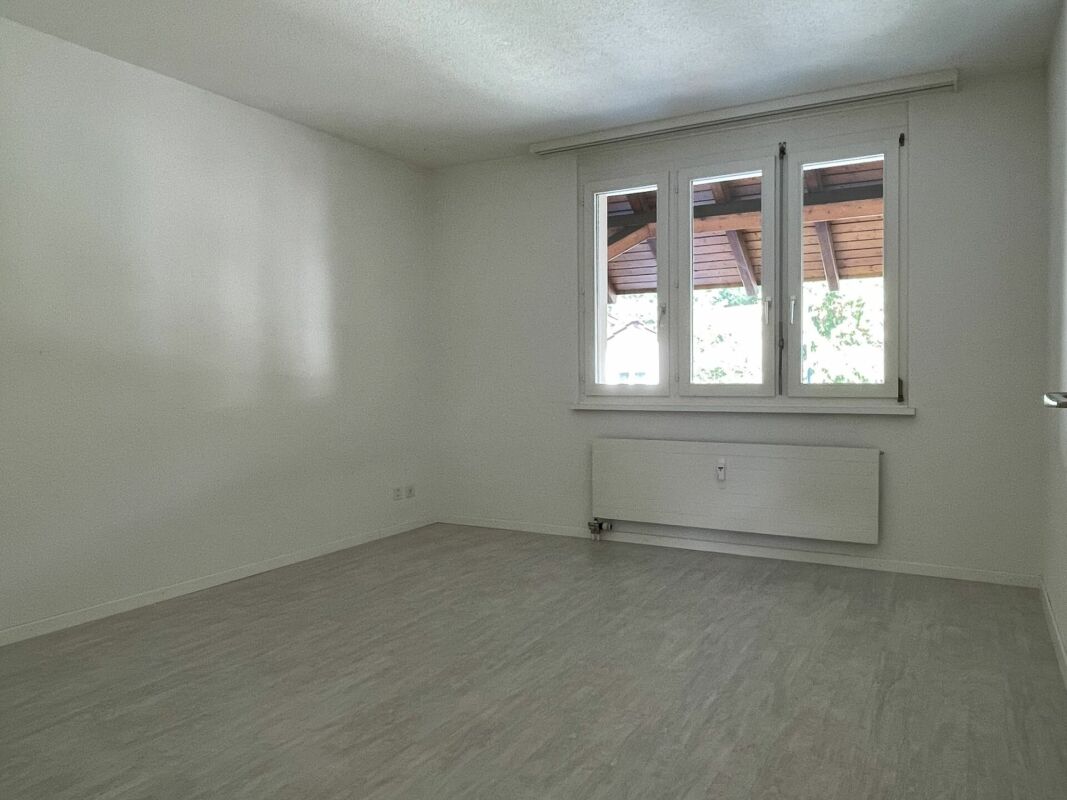 Leerer heller Raum mit Fenster und Heizkörper