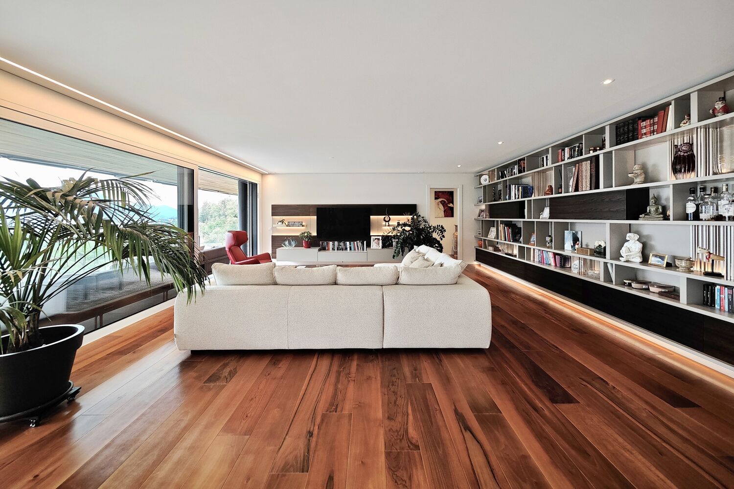Modernes Wohnzimmer mit Holzfußboden und Wandregal