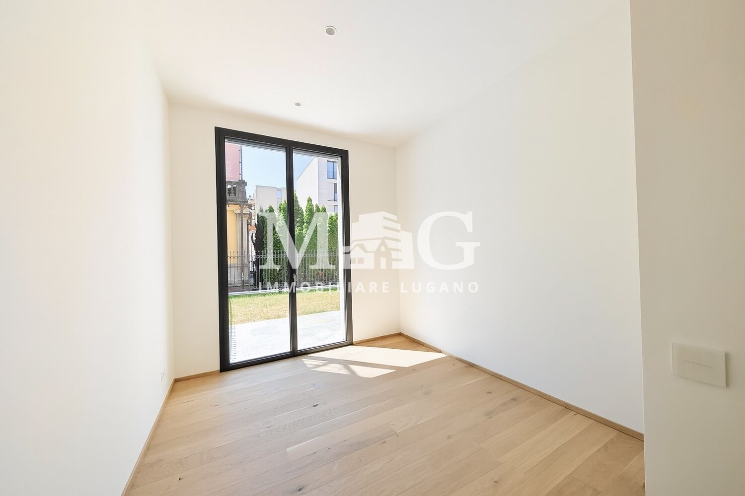 Helles, leeres Zimmer mit großem Fenster