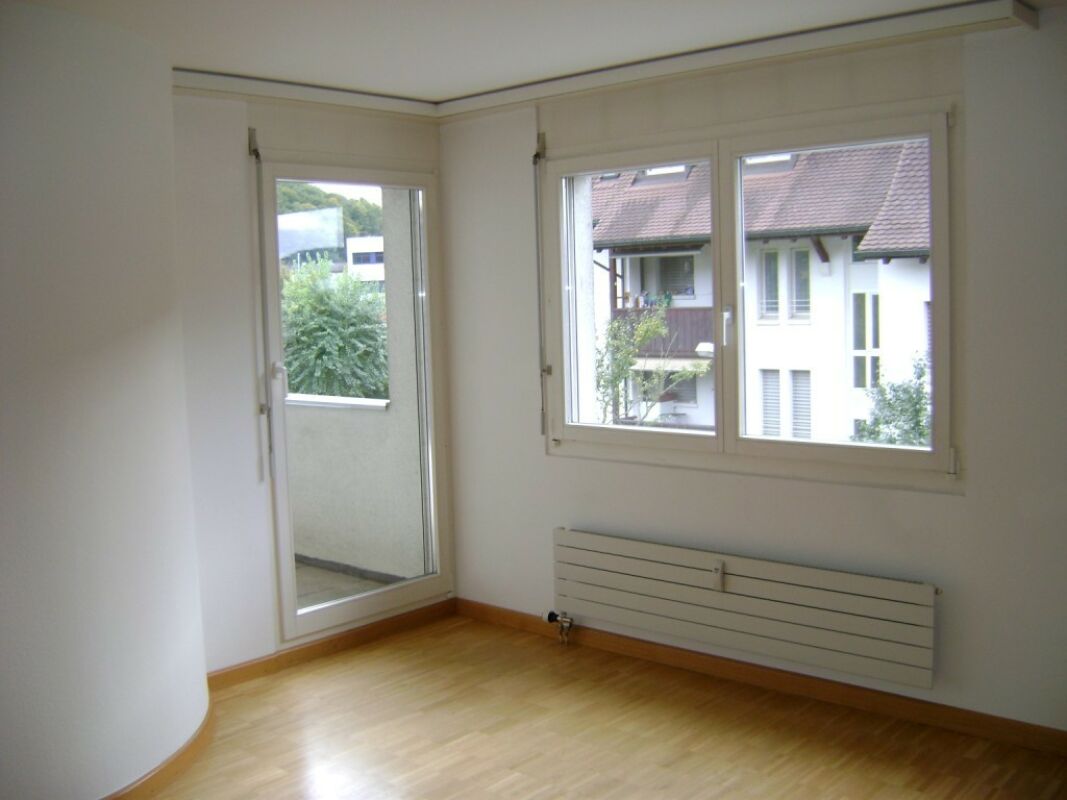 Heller leerer Wohnraum mit Balkon und Fenster