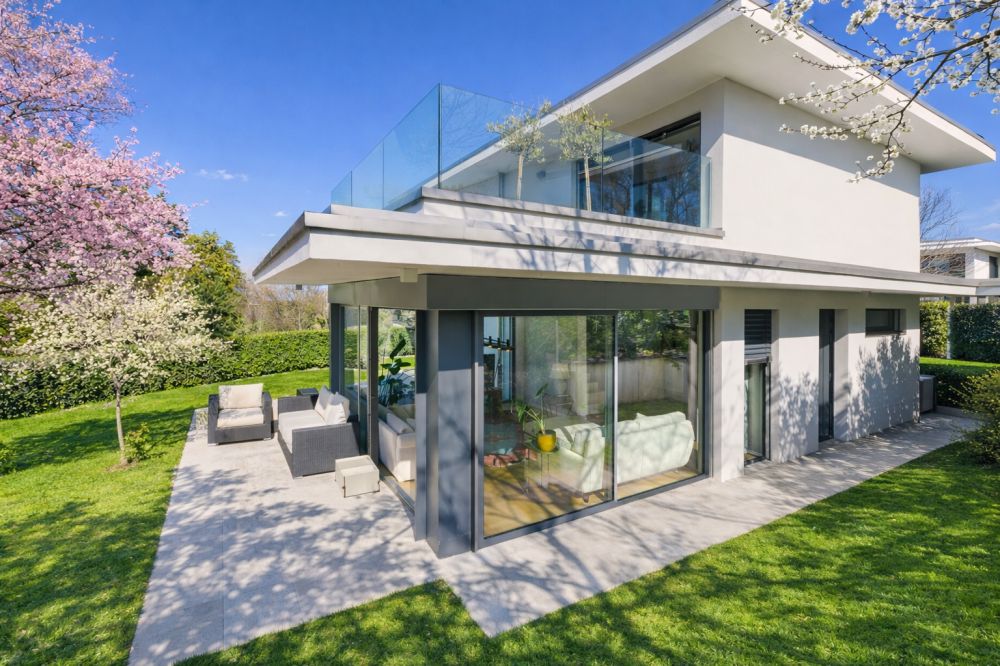 Moderne Villa mit Glasbalkon und Garten