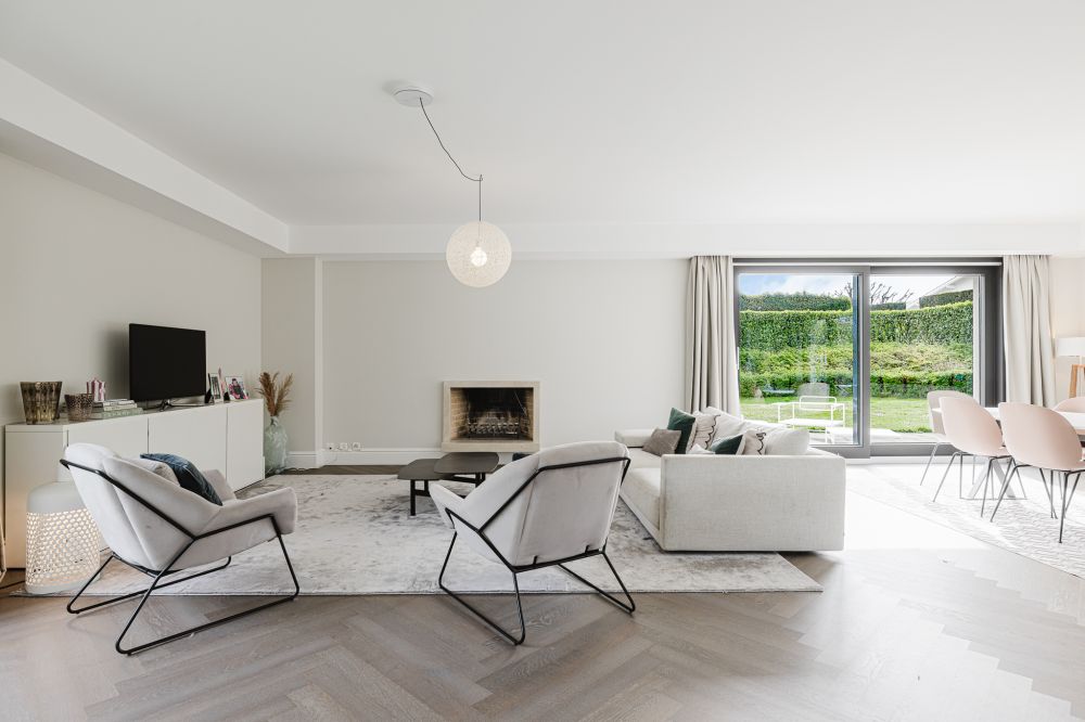 Heller offener Wohn- und Essbereich mit Kamin und Gartenblick